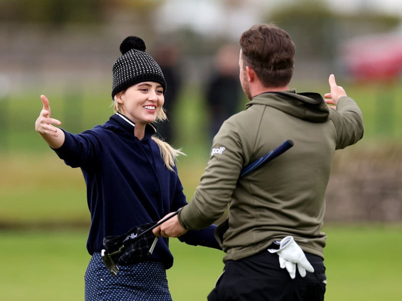 Big Little Lies actress Kathryn Newton embraces playing partner Connor Syme of Scotland on the 18th green at Carnoustie Golf Links.