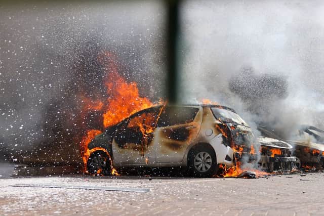Cars are seen on fire following a rocket attack from the Gaza Strip in Ashkelon, southern Israel, on October 7, 2023. Credit: AFP via Getty Images
