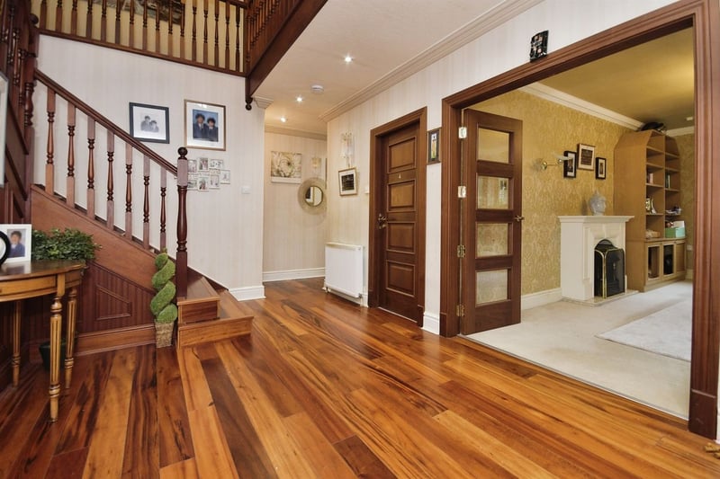 "An impressive, spacious entrance hall with open staircase, two front facing double glazed windows and glazed double doors to either sides leading to the main open plan lounge and the second front aspect lounge. With under stairs storage cupboard, wooden flooring a central heating radiator and coving to the ceiling."