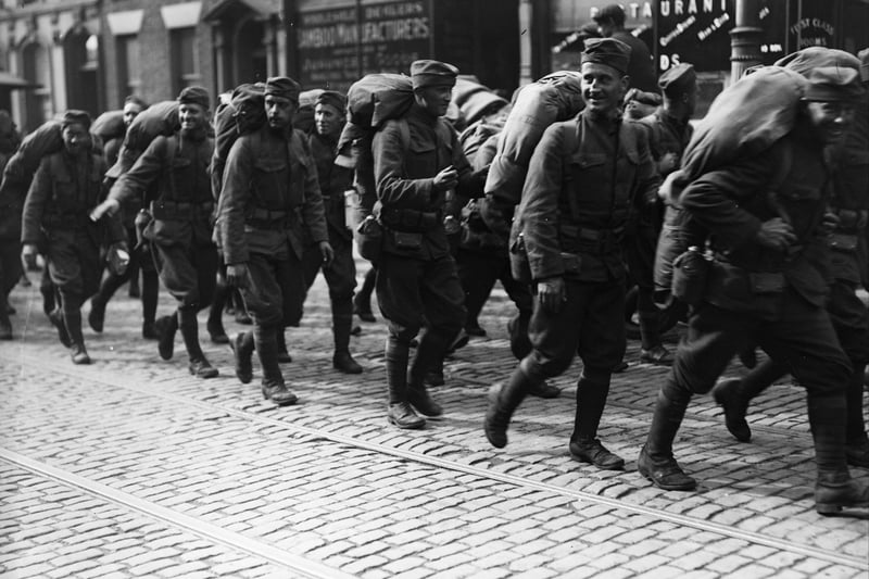Carrying heavy kitbags, smiling American troops march through the streets of Liverpool after disembarking from their ship in October 1918.