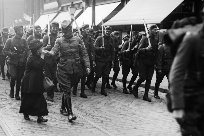 A little old lady kisses the hand of an American soldier marching through Liverpool during the First World War.
