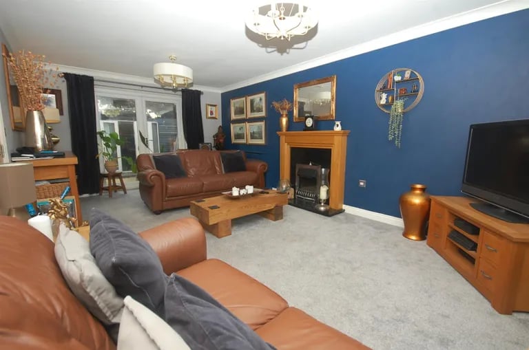 The spacious lounge with feature fireplace has French doors to the rear garden.