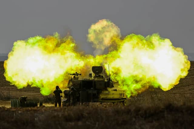 An IDF Artillery solider covers his ears as a shell is fired towards Gaza on October 11, 2023 near Netivot, Israel. Credit: Getty Images