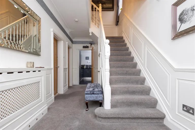 A bright entry hallway with stairs to the first floor and access to all ground floor rooms.