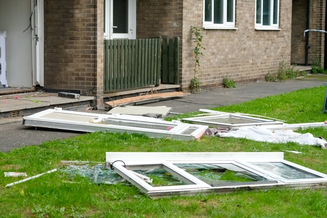 Glass from windows and doors is laid out on the grass.