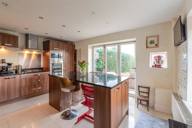A modern breakfast kitchen with appliances and glass doors to the rear.