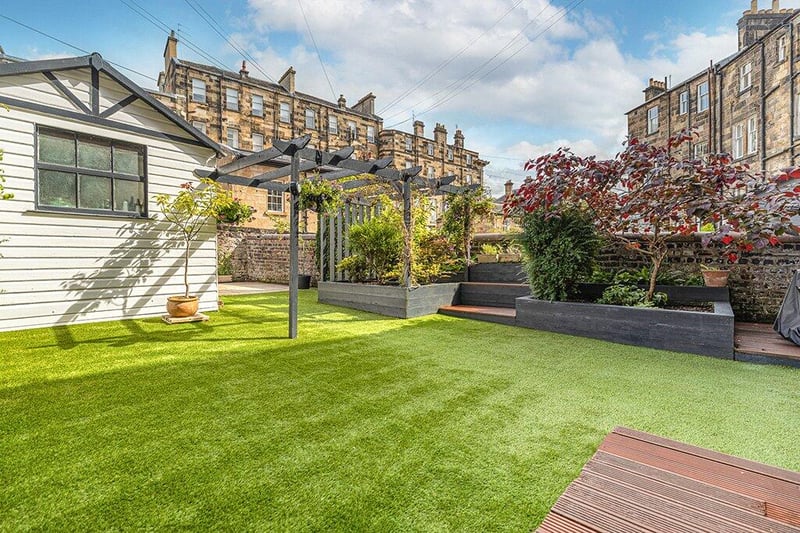 The fabulous walled private garden has been landscaped and combines a tasteful mix of artificial grass, timber decking, raised planter, and flagstone patio. 