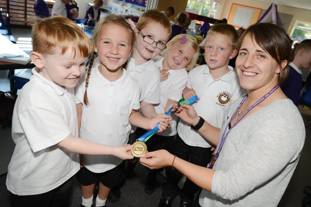 Bexhill Academy teacher, Katy McLean showing her pupils, Harry King, Abbie Thompson, Charlie Hunter, Macey Huggins and Ryan Huntrod her Rugby World Cup medal in 2014.