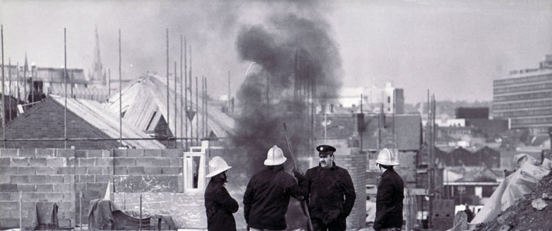 Firefighters watch over the smouldering remains of the explosives from an unexploded one ton bomb which was discovered on Lancing Road, Sheffield, in February 1985.
