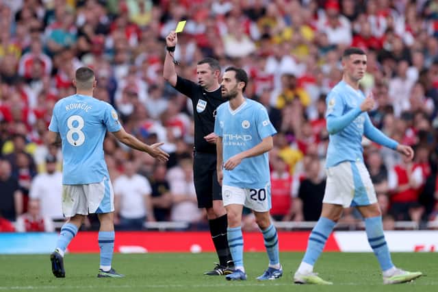  Match Referee Michael Oliver shows a yellow card to Mateo Kovacic of Manchester City during the Premier League match between Arsenal FC and Manchester City at Emirates Stadium  (Photo by Alex Pantling/Getty Images)