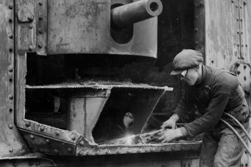 A World War I tank being broken up by a workman with an oxyacetylene torch at Barshaw Park in Paisley. World War 2 would break out just 2 years later.