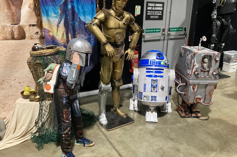 A young bounty hunter along with his droids.