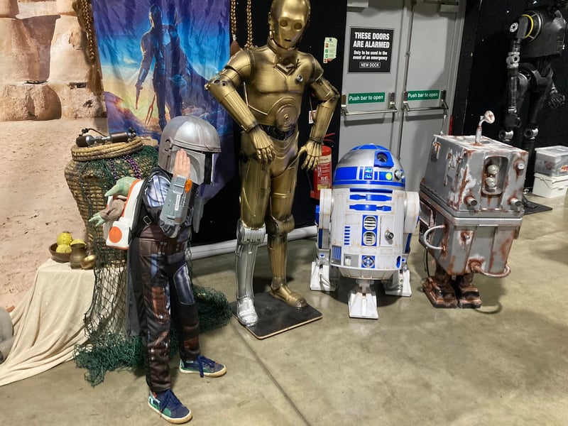 A young bounty hunter along with his droids.