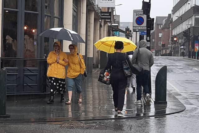 Pedestrians walk through heavy rain near Barker's Pool, Sheffield. Picture: David Kessen, National World