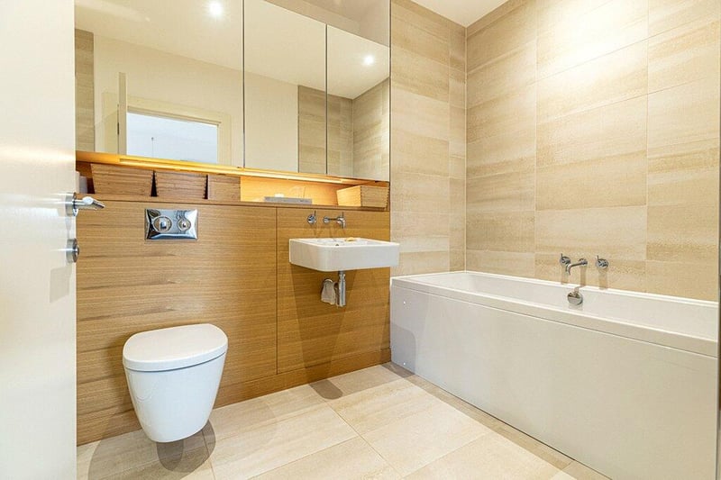 Inside the four-piece en suite bathroom comprising WC, floating wash hand basin, large tub, and walk in shower with handheld and rainwater fittings. 