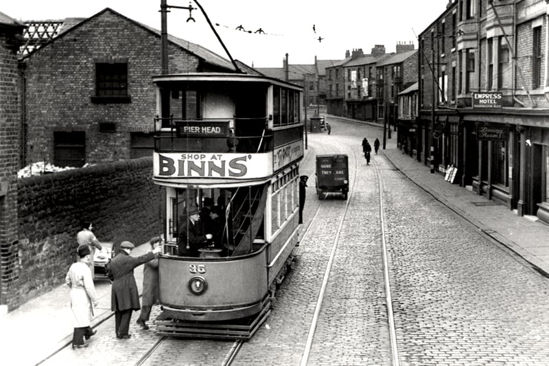 Photograph of Tram 3 on the Tyne Dock to Pierhead route stationary with people boarding. Shows the Empress Hotel on the right hand side (Newcastle Libraries)