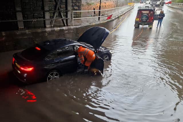 A rescue officer wades in to help a stranded motorist on Upwell Street in Sheffield in October 2023.