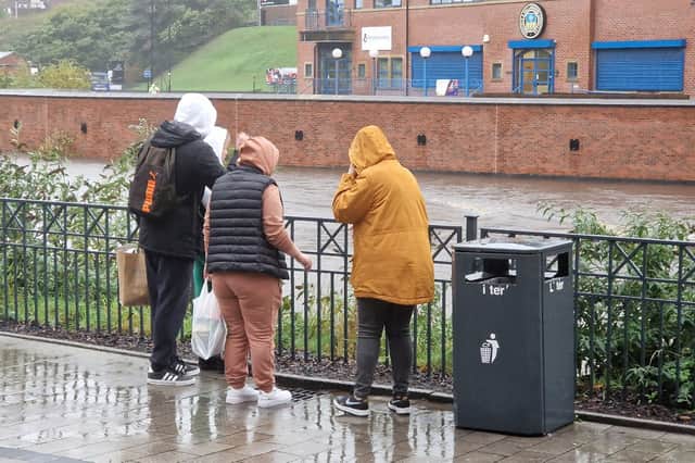 People look out over the River Don in Sheffield as the water level continues to rise during Storm Babet