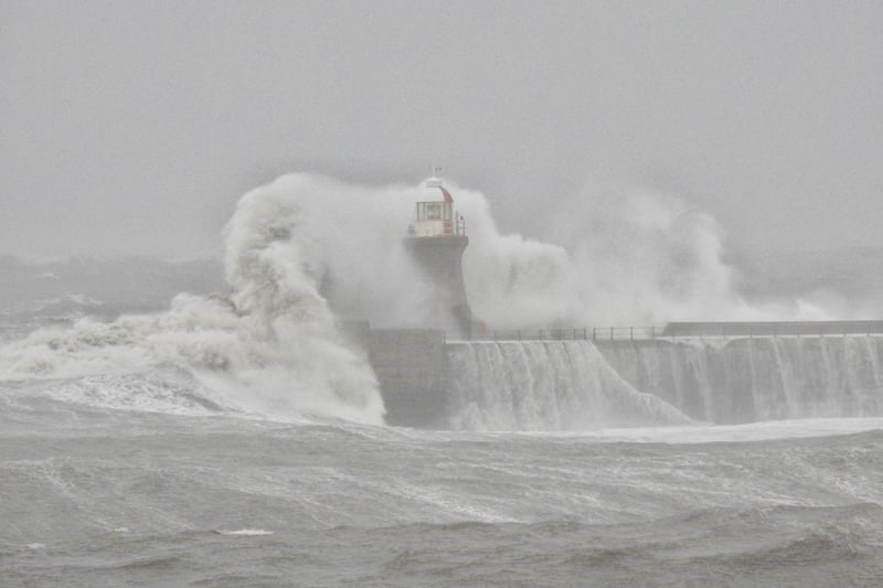 South Shields lighthouse being battered by waves.