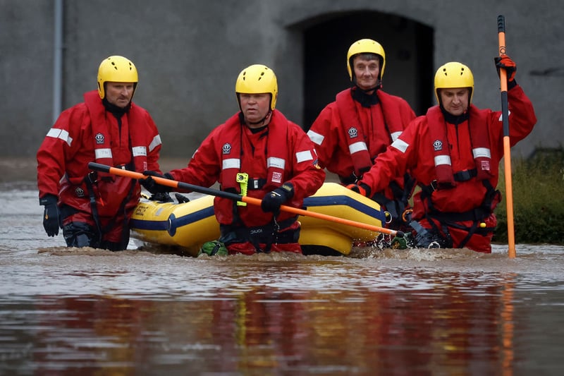 Members of the coastguard rescue team wade through the flood waters to check on people in their houses in Brechin.