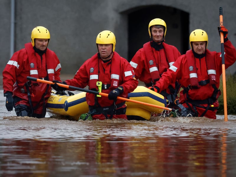 Members of the coastguard rescue team wade through the flood waters to check on people in their houses in Brechin.