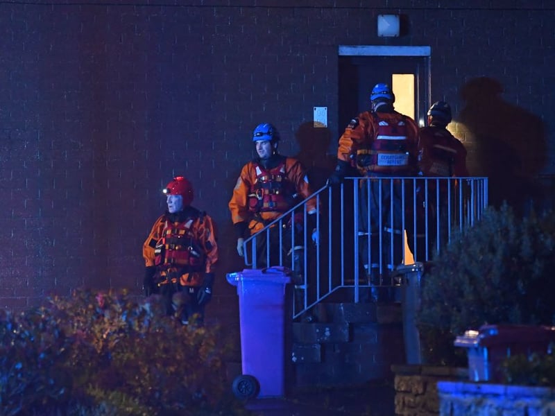 Members of the coastguard go door to door to evacuate residents along River Street in Brechin on the east of Scotland on October 19, 2023, because of the danger of the River South Esk bursting its banks dues to the wind and rain from Storm Babet.