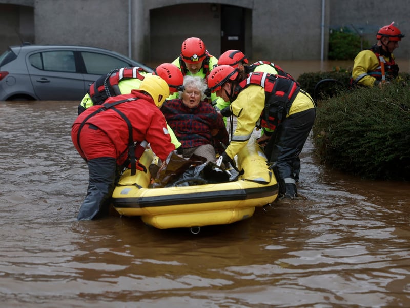 Members of the coastguard rescue a woman from flood waters surrounding the houses in Brechin.