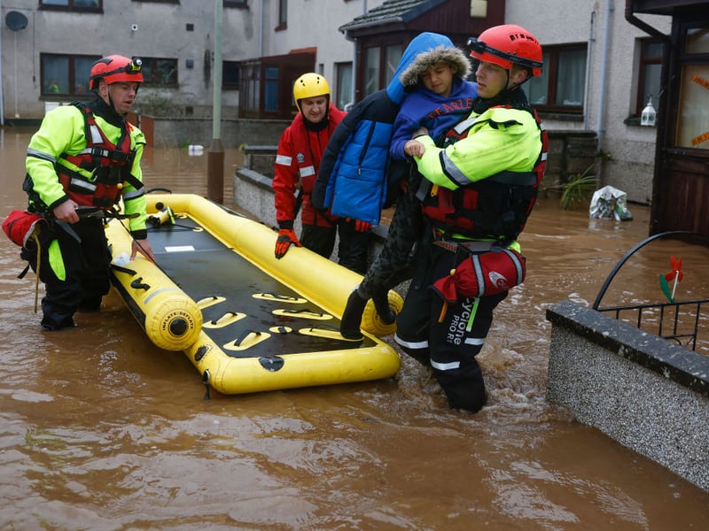 Members of the coastguard rescue a family from flood waters in Brechin after areas close to the river were overwhelmed by water which breached the flood defences in the early hours of Friday morning.