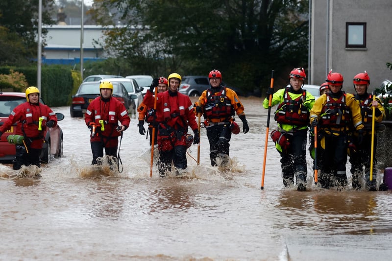 Members of the coastguard and rescue teams wade through the Brechin flood waters.