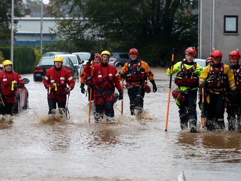 Members of the coastguard and rescue teams wade through the Brechin flood waters.