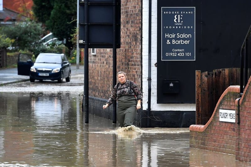A woman makes her way through the floods caused by heavy downpours of rain in the region 