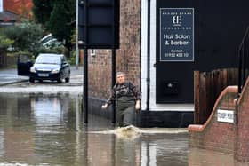 A woman makes her way through the floods caused by heavy downpours of rain