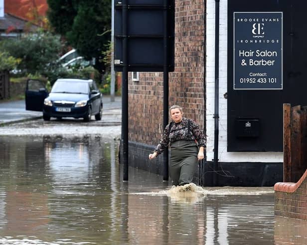 A woman makes her way through the floods caused by heavy downpours of rain