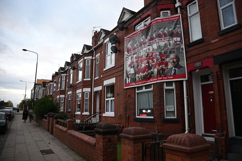 A poster depicting former Manchester United players, including Bobby Charlton, is pictured of a house near Old Trafford 