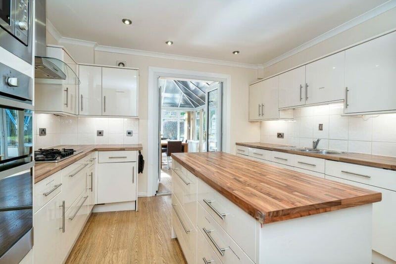Complete with an island bar, the fiitted kitchen leads through to the conservatory