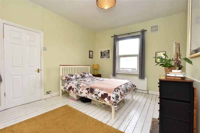 On the first floor is this charming bedroom with stripped wood flooring.