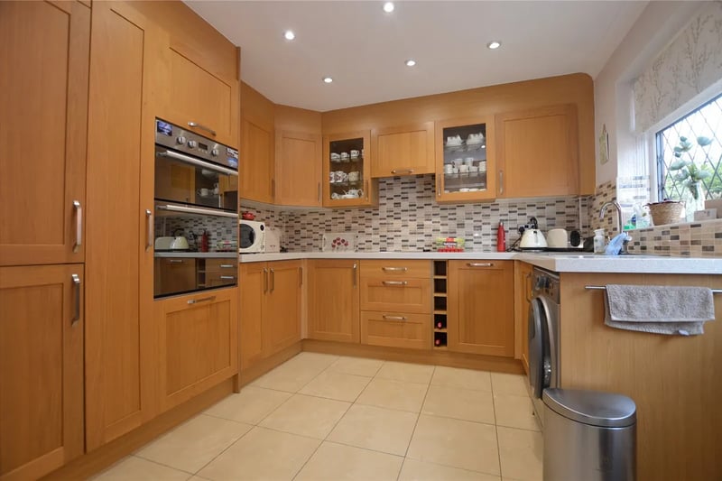 The kitchen has a range of base and wall units and integrated appliances.