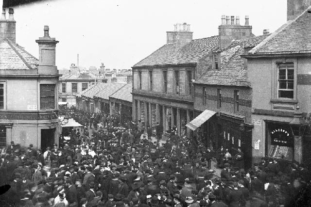 A busy street scene at Old Cross, Hamilton in 1880 - looking down Castle Street features John Dick grocer shop at corner of Cadzow St and the Douglas & Clydesdale Hotel at corner of Townhead Street