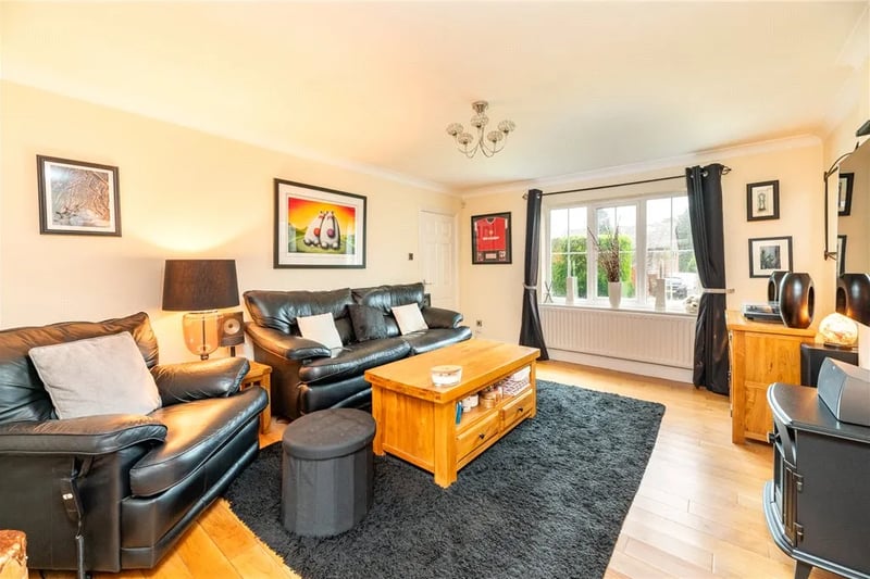 The generous living room has a large window and log burner.