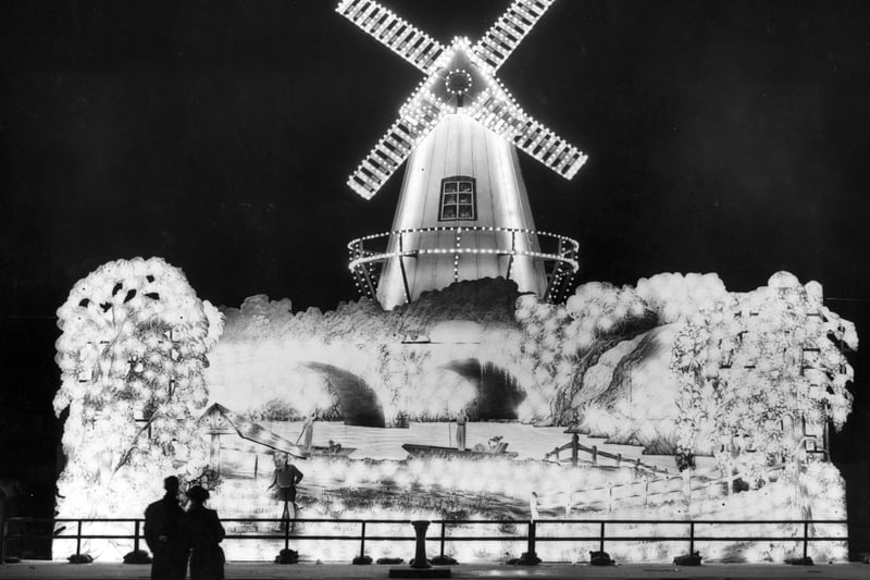 Visitors admiring the windmill, one of the illuminations at Blackpool.
