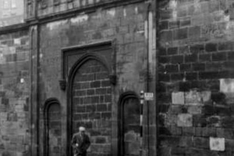 A lone man walks by the prison gates of the old Duke Street prison
