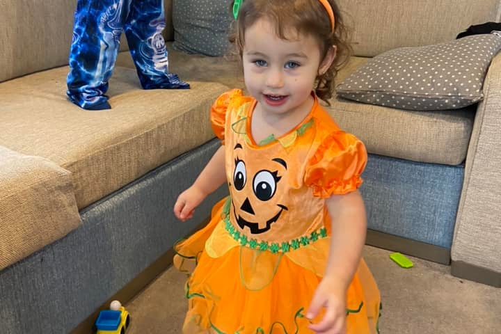 Nova aged one plays in her pumpkin outfit
Credit: Laura Laila Emmadi