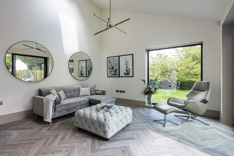 The lounge, separate from the kitchen and dining space, has comfortable furniture included and floor-length windows out into the enclosed and landscaped garden.