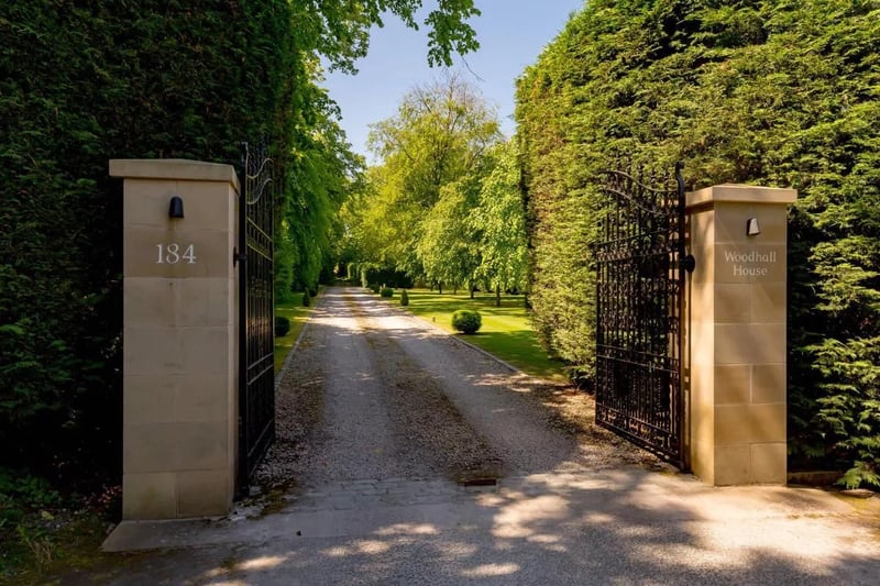 The house sits at the end of a private driveway protected by security gates.