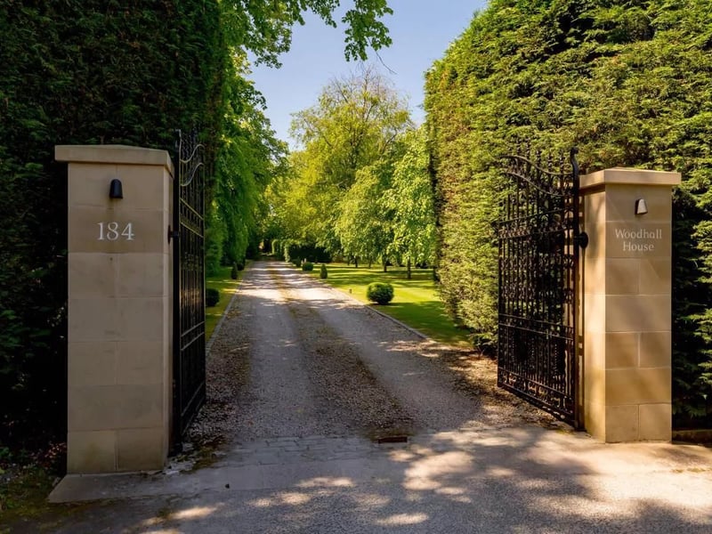 The house sits at the end of a private driveway protected by security gates.