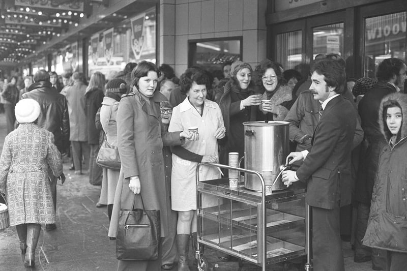 Members of Joplings staff handing out hot coffee to bargain hunters who waited outside the store all night in December 1976.