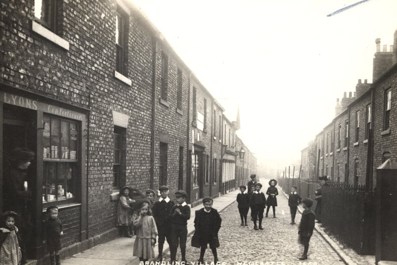  A view of Brandling Village Jesmond taken c.1910-1912. A group of children are standing in the street outside of ‘Lyons Confectioners’ shop and the front of the Brandling Arms public house can be seen in the centre to the left (Newcastle Libraries)