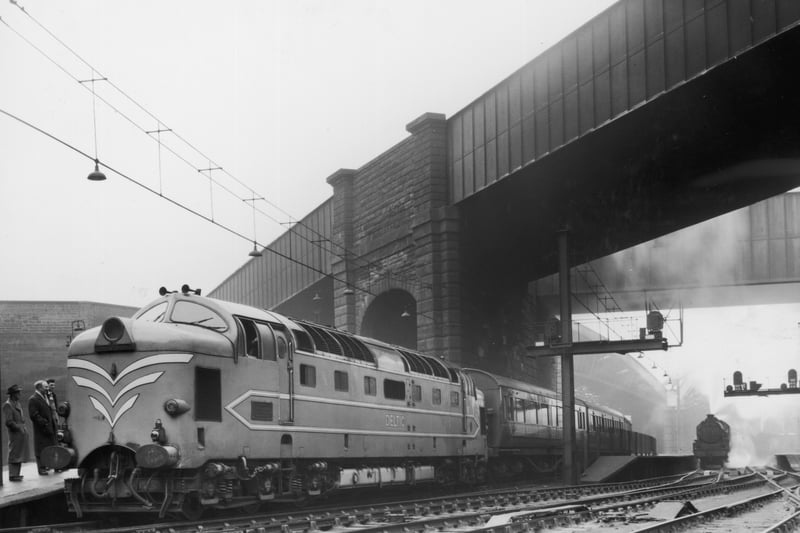 The English Electric Company’s new locomotive, the Deltic (type 5) diesel, pulling a train from Lime Street Station to London, leaving a steam train in the background.