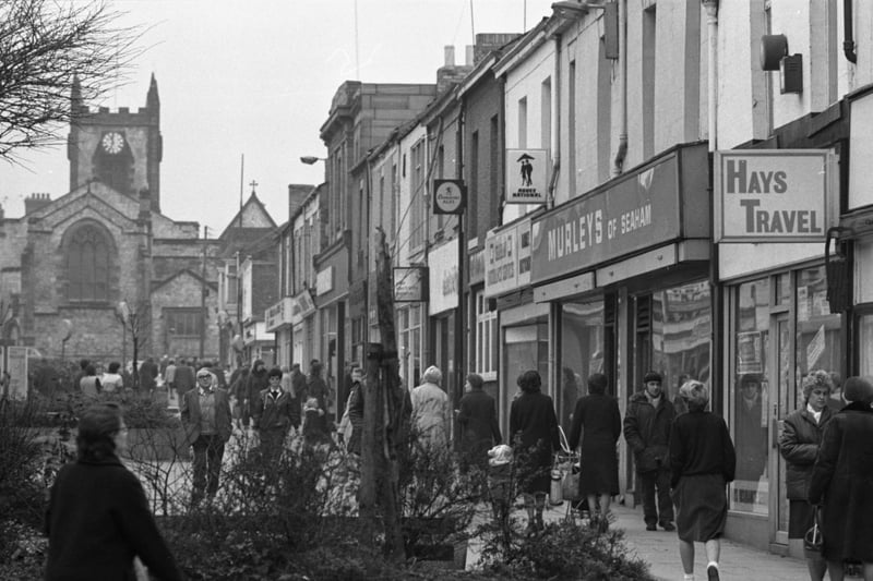 It's a cold but busy day In Seaham in this 1983 walk down Church Street.
How about a look in Murleys or Hays Travel.