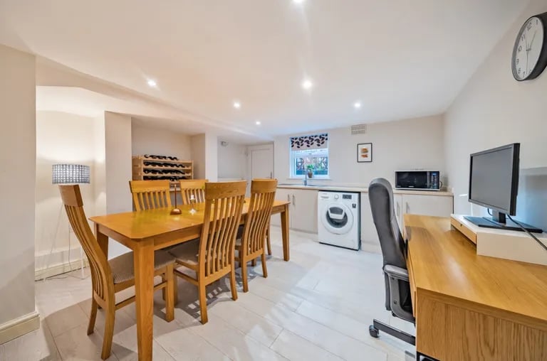 On the lower ground floor is this flexible dining room that doubles as a utility room.